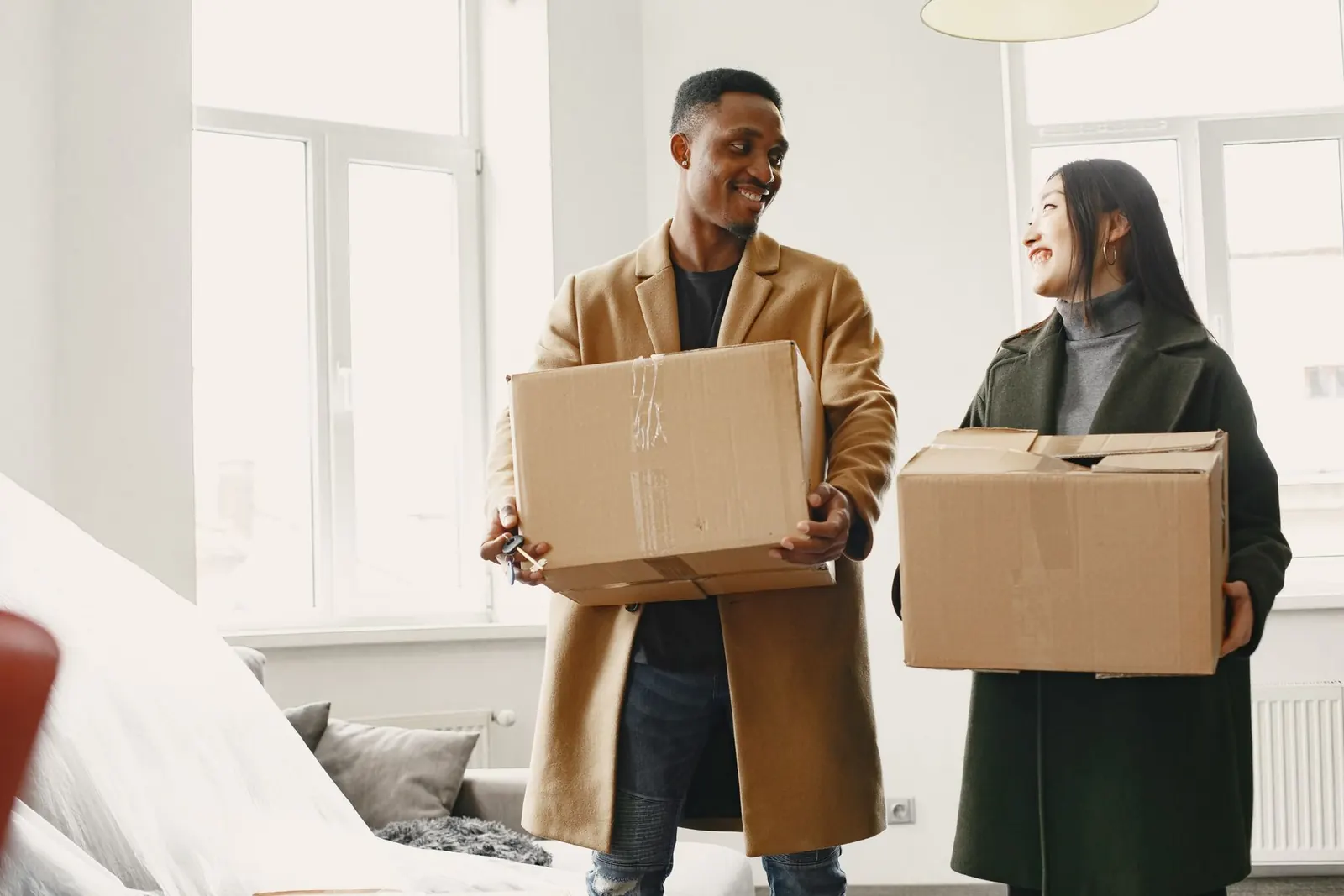 Couple holding moving boxes